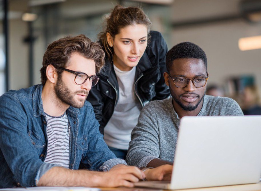 Équipe professionnelle collaborant autour d’un ordinateur portable en bureau moderne